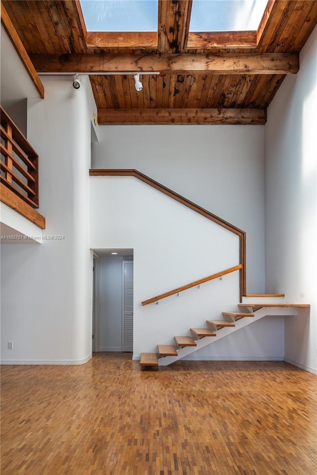 staircase featuring hardwood / wood-style flooring, wood ceiling, and vaulted ceiling with beams