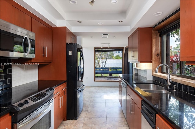 kitchen with appliances with stainless steel finishes, sink, backsplash, and plenty of natural light