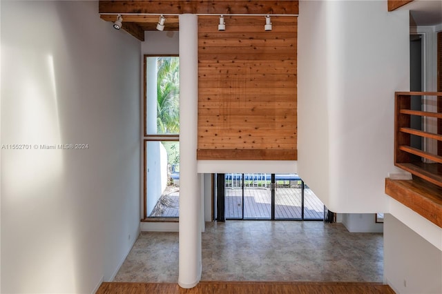 unfurnished living room with a wealth of natural light, hardwood / wood-style floors, and beam ceiling