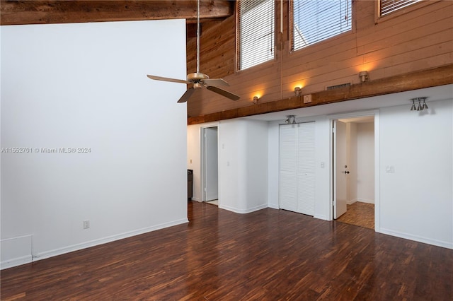 interior space with high vaulted ceiling, beamed ceiling, wooden walls, and dark hardwood / wood-style floors