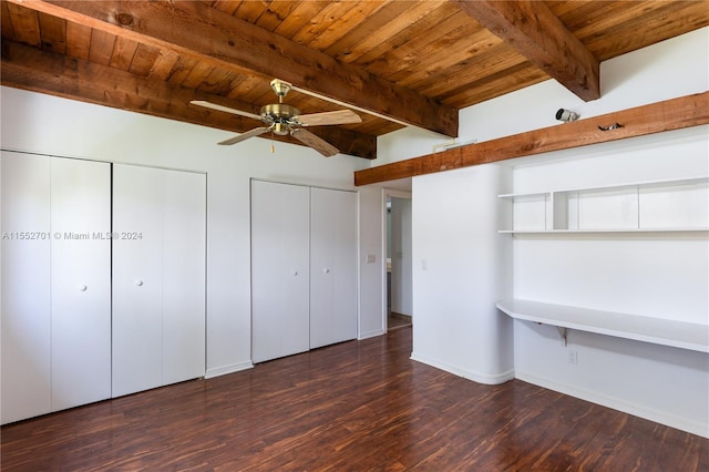 unfurnished bedroom featuring wooden ceiling, beamed ceiling, ceiling fan, dark wood-type flooring, and two closets