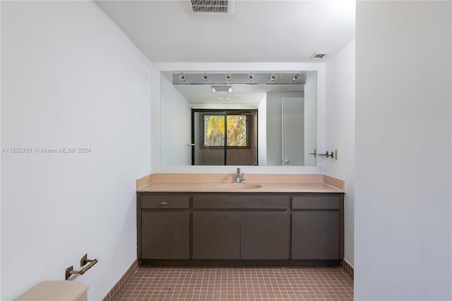 bathroom with tile patterned flooring, vanity, and toilet