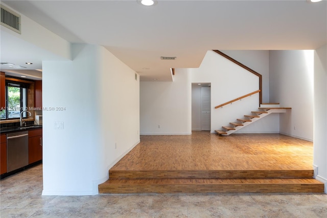 staircase featuring hardwood / wood-style floors and sink