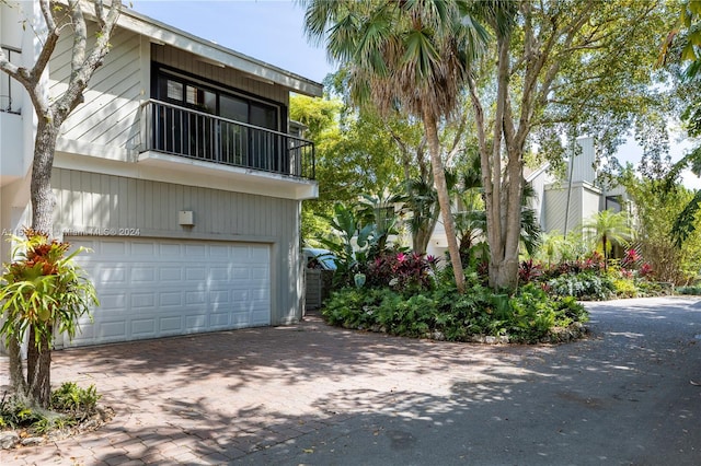 view of property exterior featuring a garage and a balcony