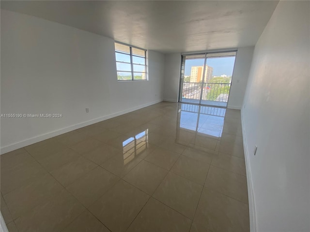 empty room featuring light tile flooring and expansive windows