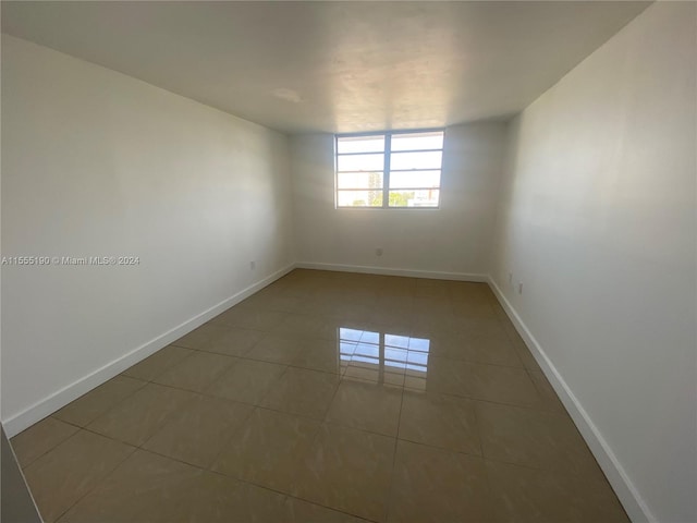 spare room with dark tile floors