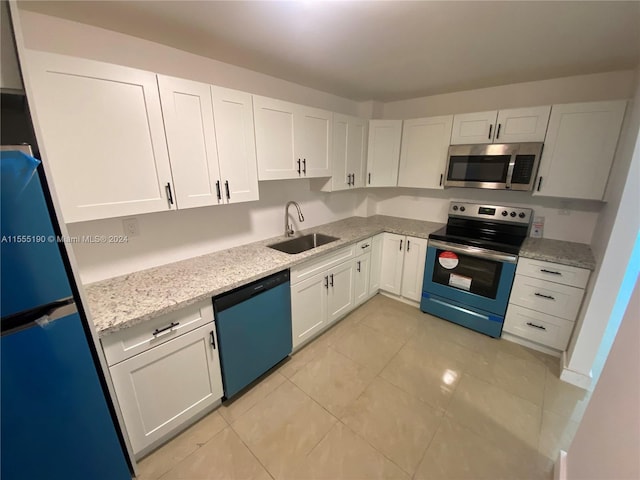 kitchen featuring light tile floors, white cabinetry, light stone counters, and stainless steel appliances