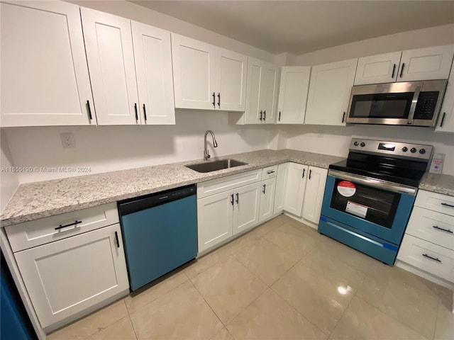 kitchen featuring light tile floors, white cabinetry, sink, and stainless steel appliances