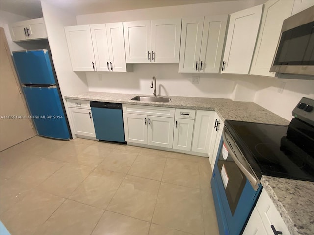 kitchen featuring white cabinets, light tile flooring, appliances with stainless steel finishes, and sink