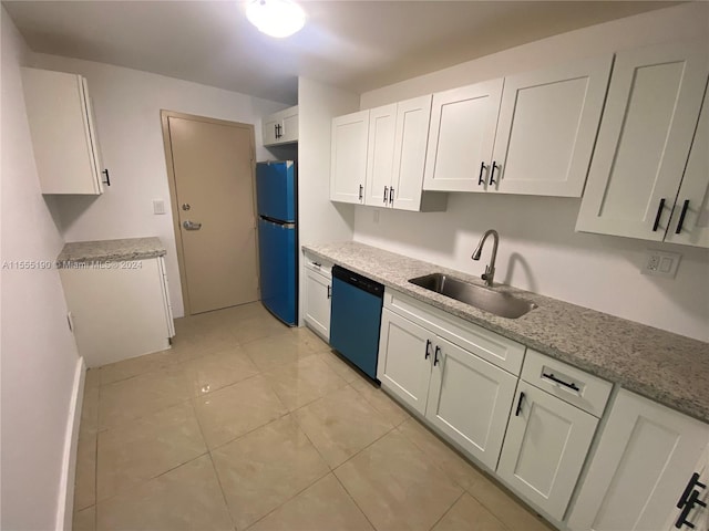 kitchen featuring sink, light tile floors, stainless steel dishwasher, white cabinetry, and black fridge