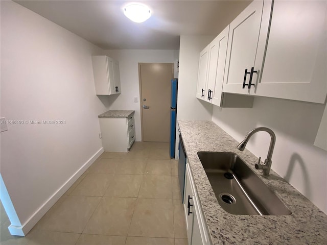 kitchen with sink, light tile floors, refrigerator, light stone countertops, and white cabinetry