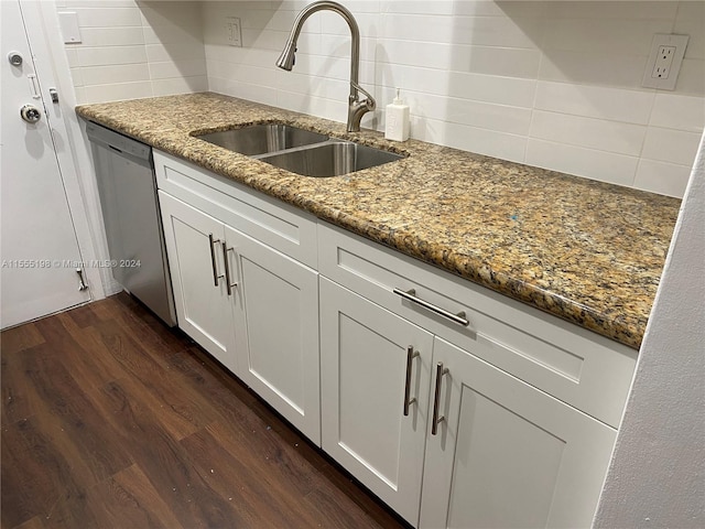 kitchen featuring dark hardwood / wood-style flooring, stainless steel dishwasher, backsplash, stone countertops, and white cabinetry