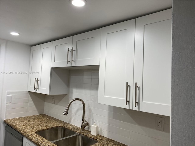 kitchen featuring backsplash, sink, white cabinets, dark stone counters, and stainless steel dishwasher