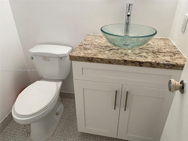 bathroom featuring vanity, tile flooring, and toilet