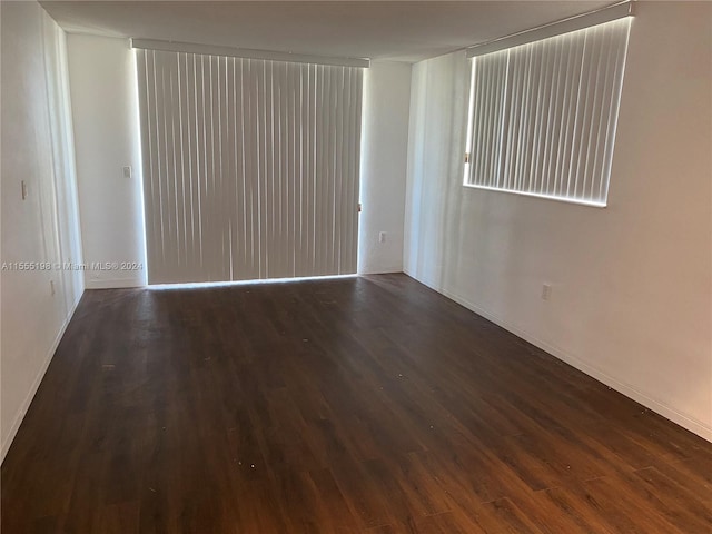 empty room with dark hardwood / wood-style flooring