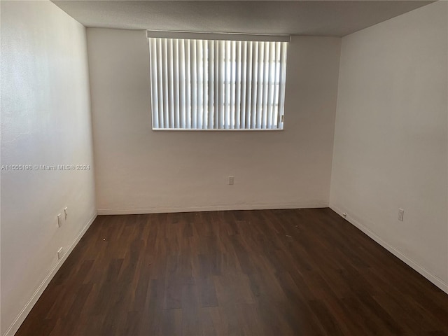 spare room featuring dark wood-type flooring