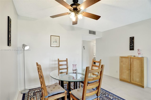 carpeted dining room with ceiling fan