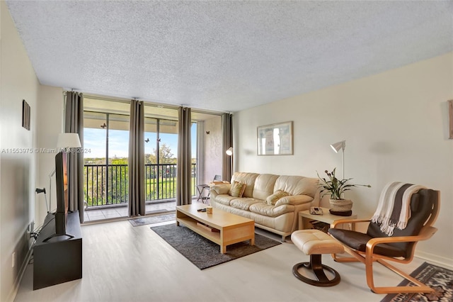 living room with floor to ceiling windows, a textured ceiling, and wood-type flooring