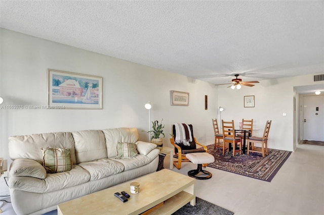 living room with a textured ceiling and ceiling fan