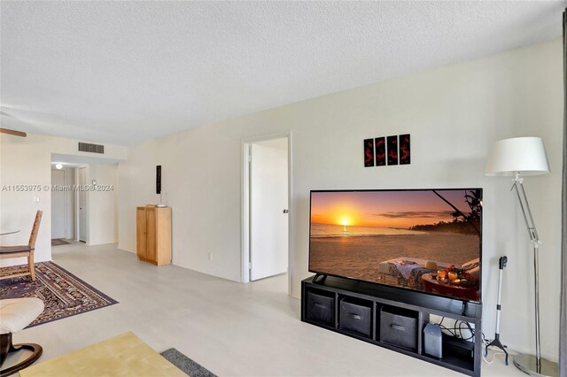 living room featuring a textured ceiling and concrete flooring