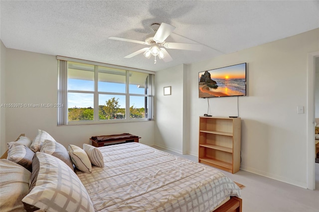 carpeted bedroom with ceiling fan and a textured ceiling