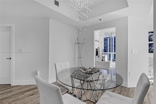 dining room featuring an inviting chandelier and light hardwood / wood-style flooring