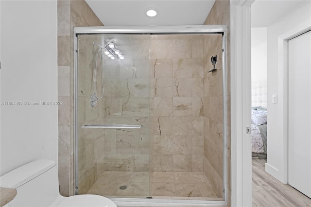 bathroom featuring toilet, walk in shower, and hardwood / wood-style flooring