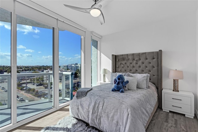 bedroom with dark hardwood / wood-style floors, access to exterior, ceiling fan, and multiple windows