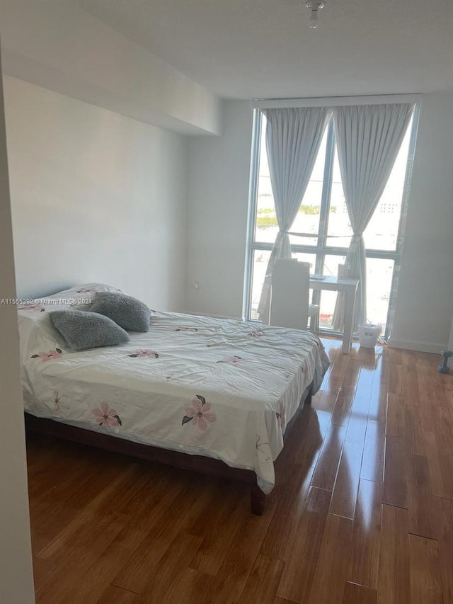 bedroom with dark hardwood / wood-style flooring and multiple windows