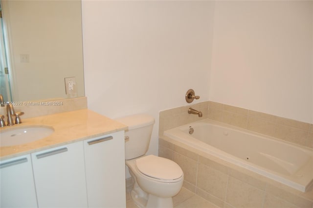 bathroom with a relaxing tiled bath, vanity, tile floors, and toilet