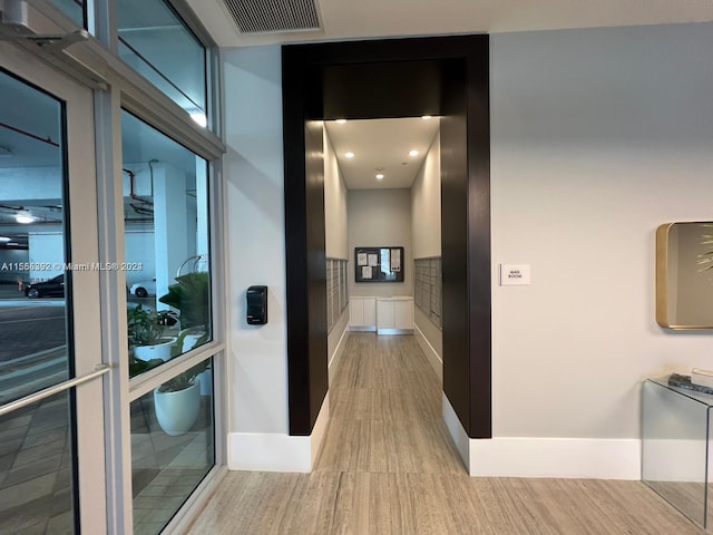 hallway with light hardwood / wood-style floors