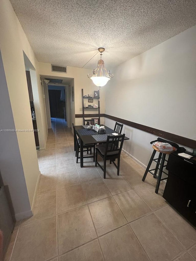 tiled dining room with a textured ceiling