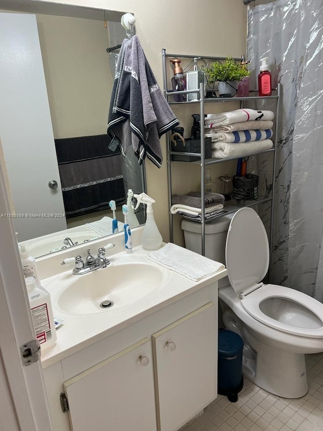 bathroom featuring toilet, tile floors, and vanity with extensive cabinet space