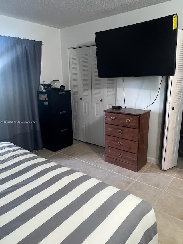 bedroom with a closet and light tile flooring