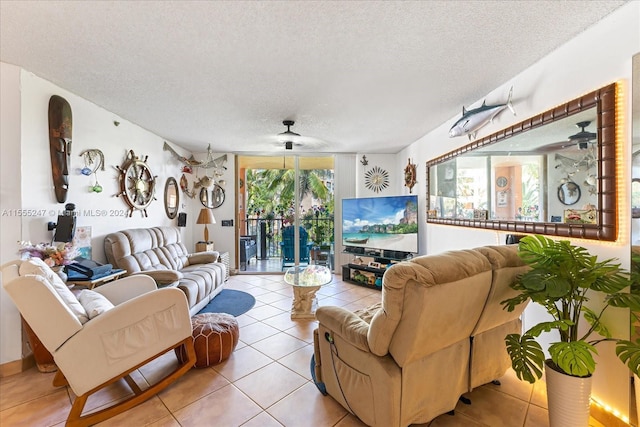 living room featuring light tile floors, ceiling fan, and a textured ceiling