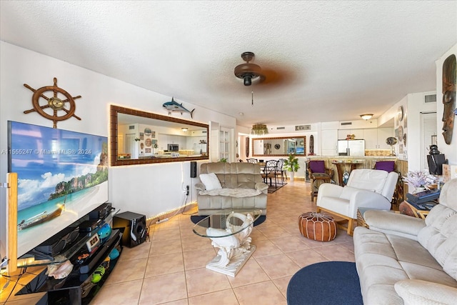 living room featuring a textured ceiling, ceiling fan, and light tile floors