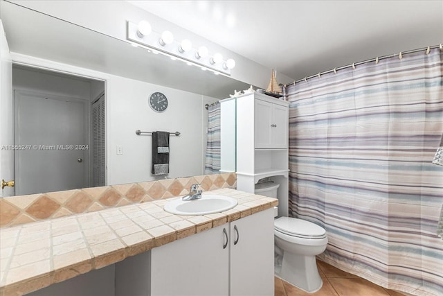 bathroom featuring toilet, tile floors, and vanity with extensive cabinet space