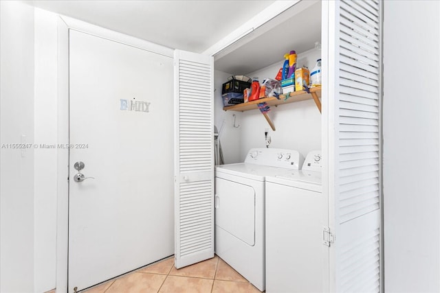 clothes washing area featuring washer and clothes dryer and light tile flooring