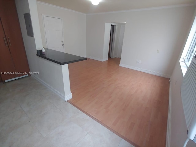 empty room with ornamental molding and light hardwood / wood-style flooring