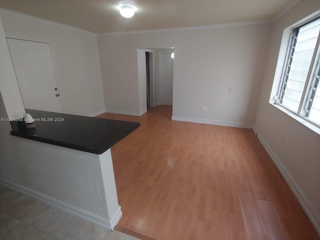 kitchen featuring a healthy amount of sunlight, ornamental molding, and light tile floors