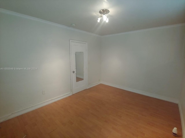 empty room featuring crown molding and light wood-type flooring