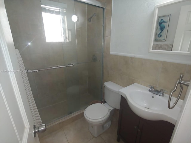 bathroom with an enclosed shower, vanity, backsplash, tile walls, and toilet