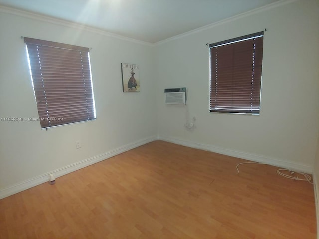 unfurnished room featuring an AC wall unit, crown molding, and light hardwood / wood-style flooring