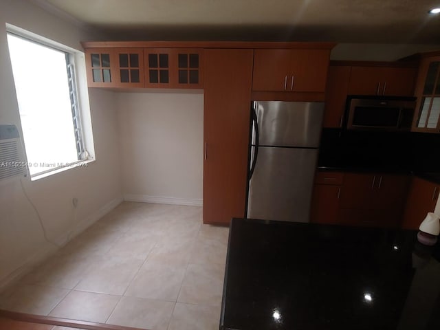 kitchen with light tile flooring and stainless steel refrigerator