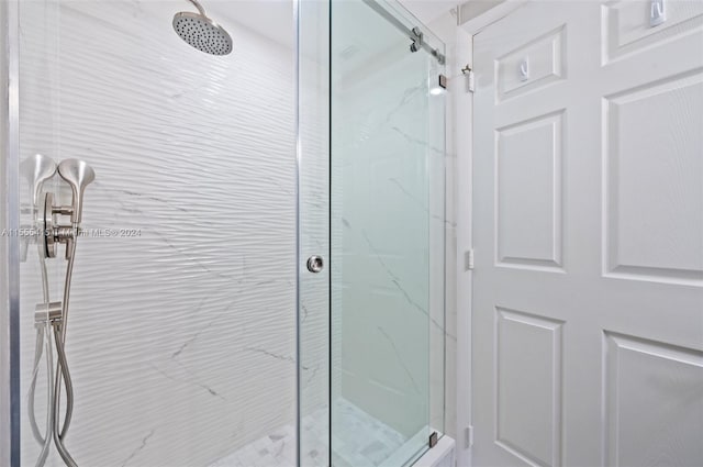 bathroom with a shower with door