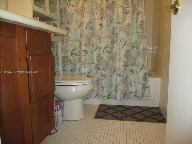 bathroom featuring tile patterned floors, toilet, and shower / bathtub combination with curtain