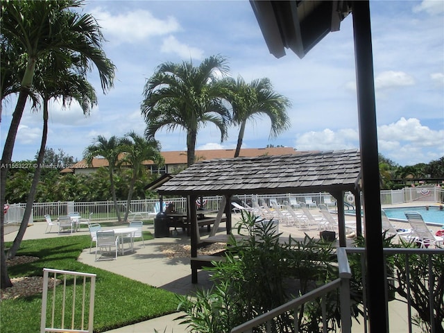 view of community featuring a lawn, a patio area, and a swimming pool