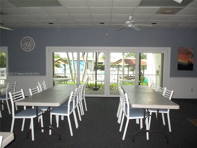 carpeted dining space featuring a paneled ceiling, plenty of natural light, and ceiling fan