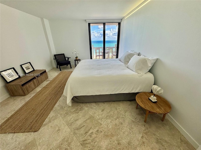 bedroom featuring access to exterior and a water view