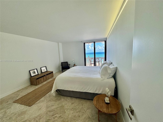 bedroom featuring a wall of windows and a water view